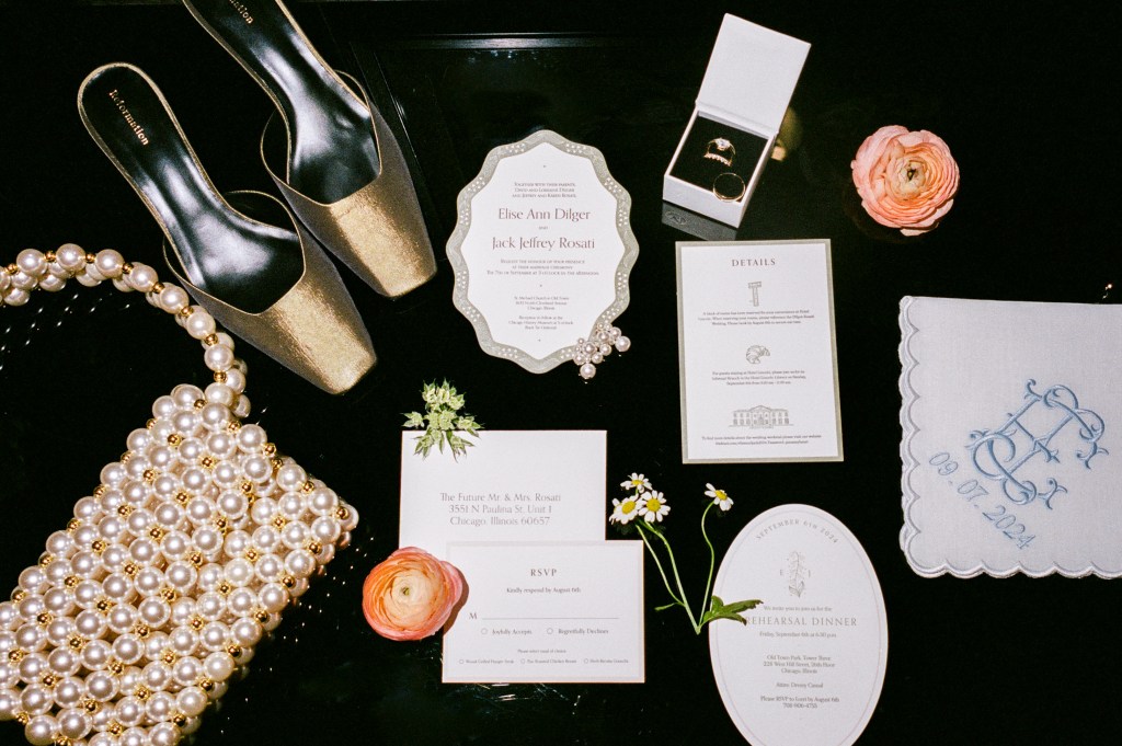 Flash photograph of wedding invitation suite with bridal accessories and details